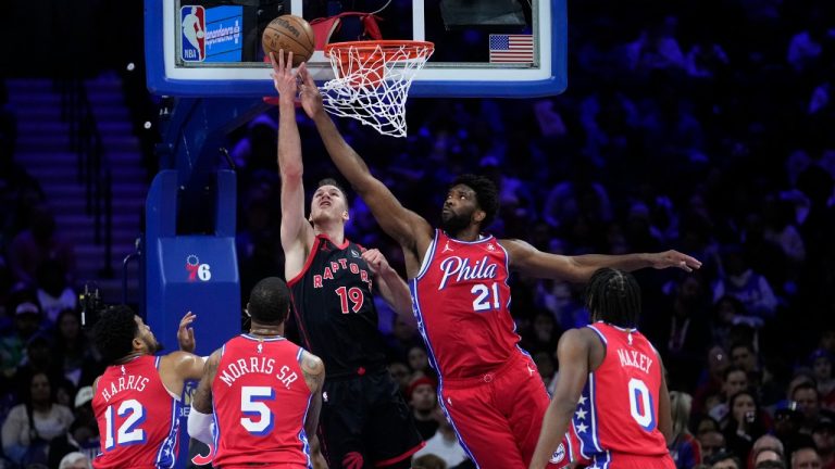 Toronto Raptors' Jakob Poeltl (19) goes up for a shot against Philadelphia 76ers' Joel Embiid (21) during the first half of an NBA basketball game, Friday, Dec. 22, 2023, in Philadelphia. (Matt Slocum/AP)