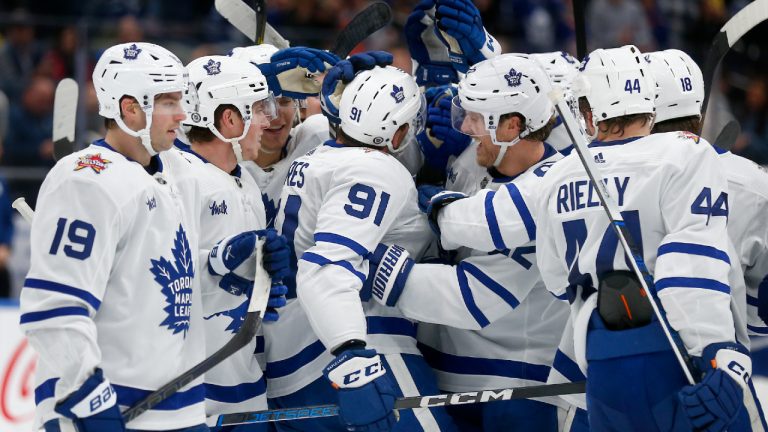 Toronto Maple Leafs center John Tavares (91) is surrounded by teammates after scoring with an assist during the third period of an NHL hockey game against the New York Islanders Monday, Dec. 11, 2023, in New York. Tavares recorded his 1,000th career NHL point (435 goals, 565 assists) on the play. (John Munson/AP)