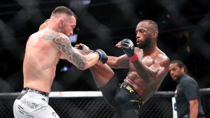 Welterweight fighter Colby Covington, left, is hit by a kick from UFC welterweight champion Leon Edwards during the UFC 296 mixed martial arts event Saturday, Dec. 16, 2023, in Las Vegas. Edwards retained his title by unanimous decision. (Steve Marcus/Las Vegas Sun via AP)