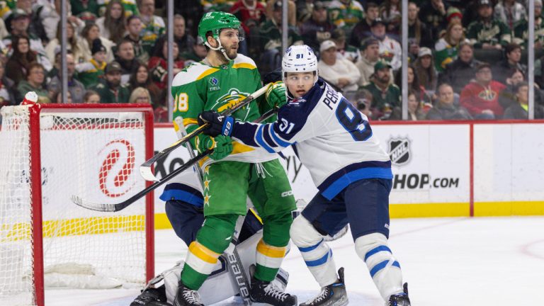 Minnesota Wild right wing Ryan Hartman, left, battles with Winnipeg Jets center Cole Perfetti, right, in front of the net during the first period of an NHL hockey game Sunday, Dec. 31, 2023, in St. Paul, Minn. (Bailey Hillesheim/AP)