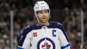 Winnipeg Jets center Adam Lowry (17) looks on before a face-off against the Minnesota Wild during the first period of an NHL hockey game Sunday, Dec. 31, 2023, in St. Paul, Minn. (Bailey Hillesheim/AP)