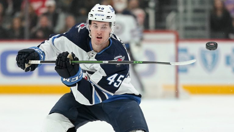 Winnipeg Jets defenceman Declan Chisholm flips the puck ahead against the Detroit Red Wings in the first period of an NHL hockey game Thursday, Jan. 13, 2022, in Detroit. (Paul Sancya/AP)