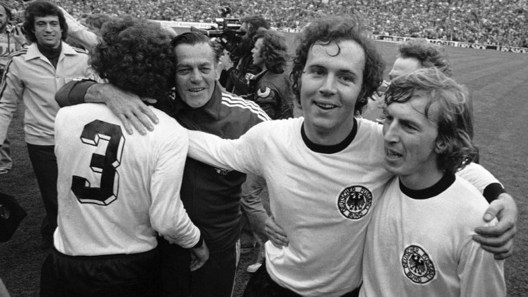 West German national soccer team captain Franz Beckenbauer, second from right, embraces his team mate, forward Juergen Grabowski while walking around the Olympic stadium, after West Germany beat the Netherlands 2-1 in the Football World Cup Final game at the Olympic Stadium in Munich, Germany, on July 7, 1974. (AP Photo, File)