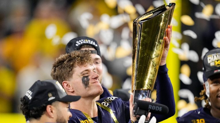 Michigan quarterback J.J. McCarthy celebrates with the trophy after their win against Washington in the national championship NCAA College Football Playoff game Monday, Jan. 8, 2024, in Houston. (AP Photo/Eric Gay)