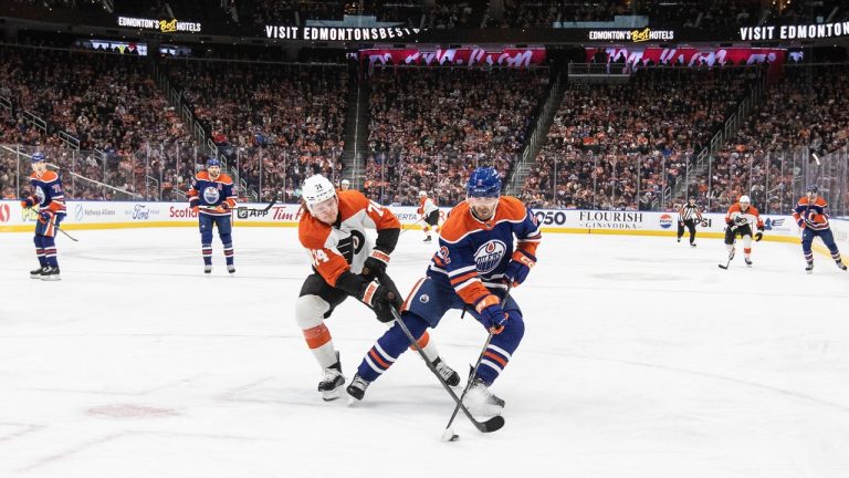 Philadelphia Flyers' Owen Tippett (74) and Edmonton Oilers' Evan Bouchard (2) battle for the puck during first period NHL action in Edmonton, Tuesday, Jan. 2, 2024. (Jason Franson/CP)