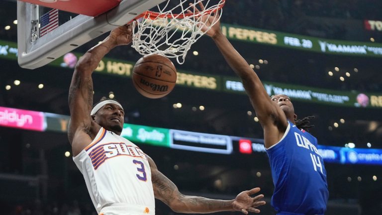 Phoenix Suns guard Bradley Beal, left, dunks as Los Angeles Clippers guard Terance Mann defends during the first half of an NBA basketball game Monday, Jan. 8, 2024, in Los Angeles. (Mark J. Terrill/AP)