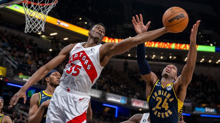 Former Toronto Raptors centre Christian Koloko (35) grabs for a rebound against Indiana Pacers guard Buddy Hield (24) during the first half of an NBA basketball game in Indianapolis, Monday, Jan. 2, 2023. (Doug McSchooler/AP)