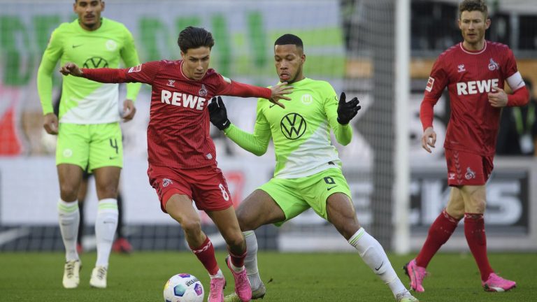 Cologne's Denis Huseinbasic, left, and Wolfsburg's Aster Vranckx battle for the ball during the Bundesliga soccer match between VfL Wolfsburg and 1. FC Koln at Volkswagen Arena, Wolfsburg, Germany, Saturday Jan. 27, 2024. (Swen Pfortner/dpa via AP)