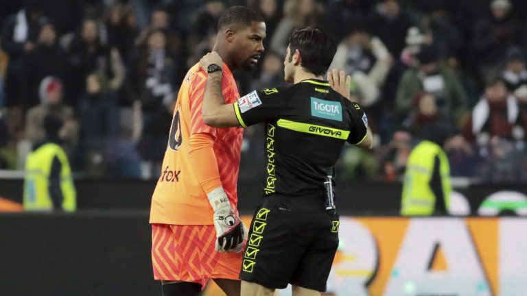 Referee Enzo Maresca, right, speaks to AC Milan's Mike Maignan during the Italian Serie A soccer match between Udinese and AC Milan that was suspended, at the Friuli stadium in Udine, Italy, Saturday, Jan. 20, 2024. Racist abuse aimed at AC Milan goalkeeper Mike Maignan prompted a top-tier Italian league game at Udinese to be suspended briefly during the first half. Maignan left the field after the insults which followed a goal for Milan. (Andrea Bressanutti/LaPresse via AP)