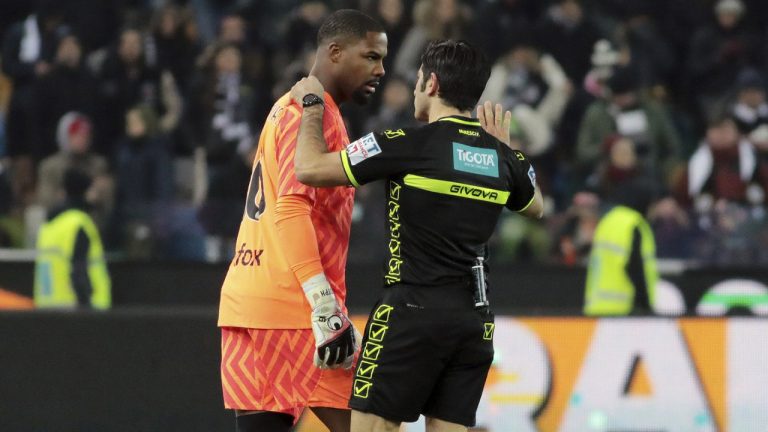 Referee Enzo Maresca, right, speaks to AC Milan's Mike Maignan during the Italian Serie A soccer match between Udinese and AC Milan that was suspended, at the Friuli stadium in Udine, Italy, Saturday, Jan. 20, 2024. (Andrea Bressanutti/LaPresse via AP)