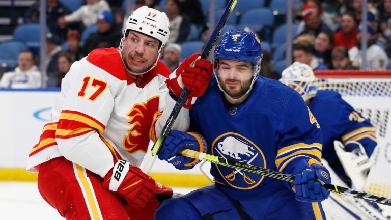 Calgary Flames left wing Milan Lucic (17) and Buffalo Sabres defenseman Will Butcher (4) battle for position during the second period of an NHL hockey game, Thursday, Nov. 18, 2021, in Buffalo, N.Y. (Jeffrey T. Barnes/AP Photo)