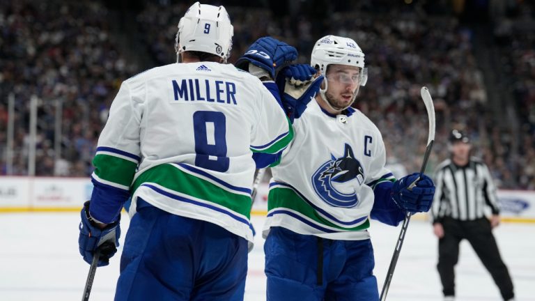 Vancouver Canucks center J.T. Miller (9) is congratulated after scoring a goal by Vancouver Canucks defenseman Quinn Hughes (43) in the second period of an NHL hockey game on Wednesday, Nov. 22, 2023, in Denver. (David Zalubowski/AP)