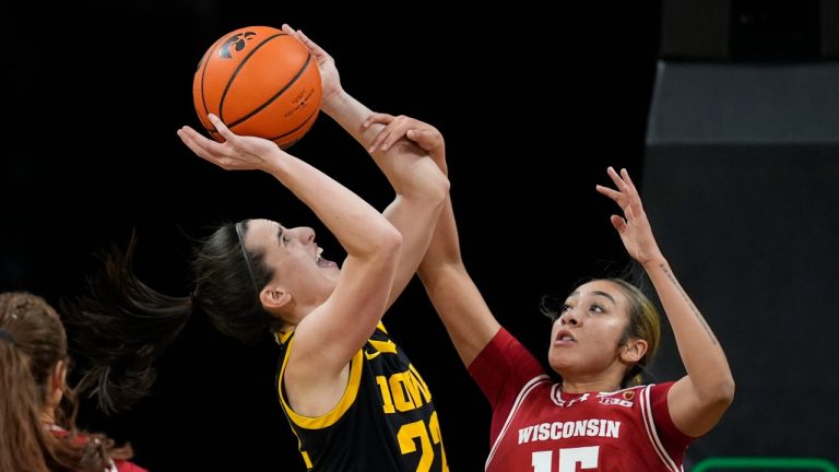 Iowa guard Caitlin Clark (22) is fouled by Wisconsin guard Sania Copeland (15) while driving to the basket during the first half of an NCAA college basketball game Tuesday, Jan. 16, 2024, in Iowa City, Iowa. (Charlie Neibergall/AP Photo)