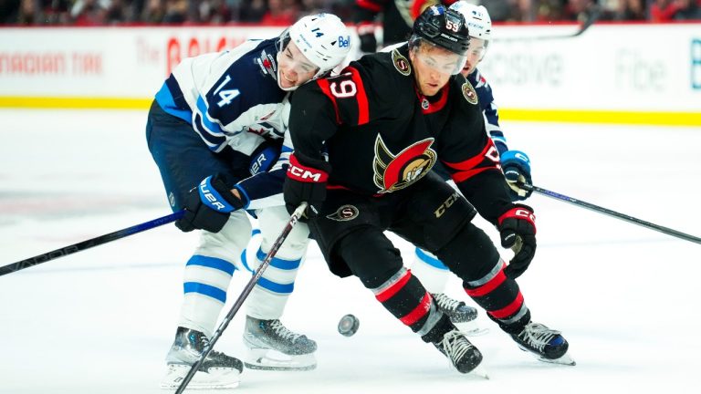 Winnipeg Jets defenceman Ville Heinola (14) and Ottawa Senators left wing Angus Crookshank (59) fight for the puck during second period pre-season NHL hockey action in Ottawa on Friday, Sept. 29, 2023. (Sean Kilpatrick/CP)