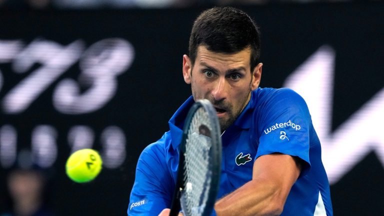 Serbia's Novak Djokovic plays a backhand return to Croatia's Dino Prizmic during their first round match at the Australian Open tennis championships at Melbourne Park, Melbourne, Australia, Sunday, Jan. 14, 2024. (Andy Wong/AP)