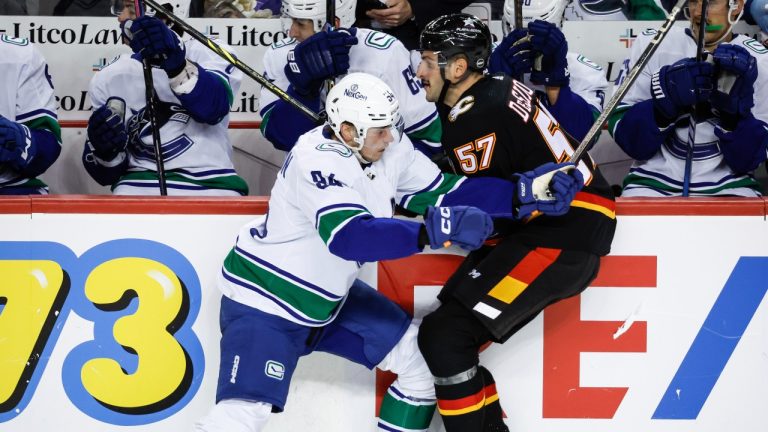 Vancouver Canucks forward Linus Karlsson, left, checks Calgary Flames defenceman Nick DeSimone during third period NHL hockey action in Calgary, Thursday, Nov. 16, 2023. (Jeff McIntosh/CP)