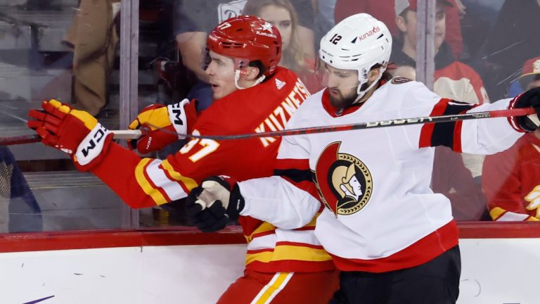 Calgary Flames' Yan Kuznetsov, left, is hit by Ottawa Senators' Mark Kastelic during second period NHL hockey action in Calgary, Tuesday, Jan. 9, 2024. (Larry MacDougal/CP)