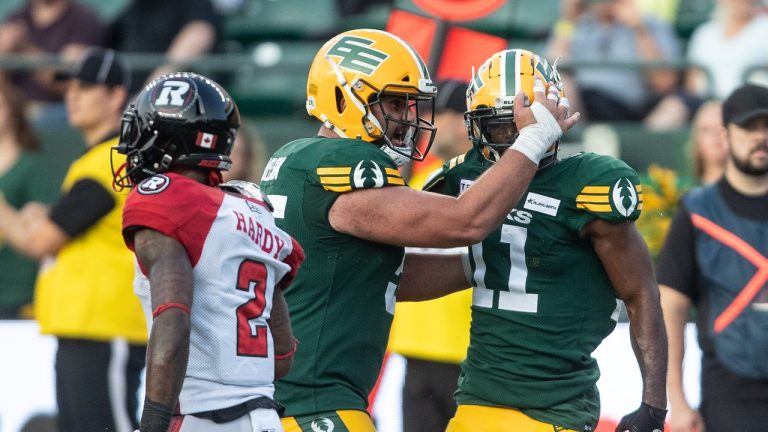 Ottawa Redblacks' Justin Hardy (2) walks past as the Edmonton Elks' Ed Gainey (11) and Cole Nelson (55) celebrate a tackle during second half CFL action in Edmonton, Alta., on Sunday August 27, 2023. (Jason Franson/CP)