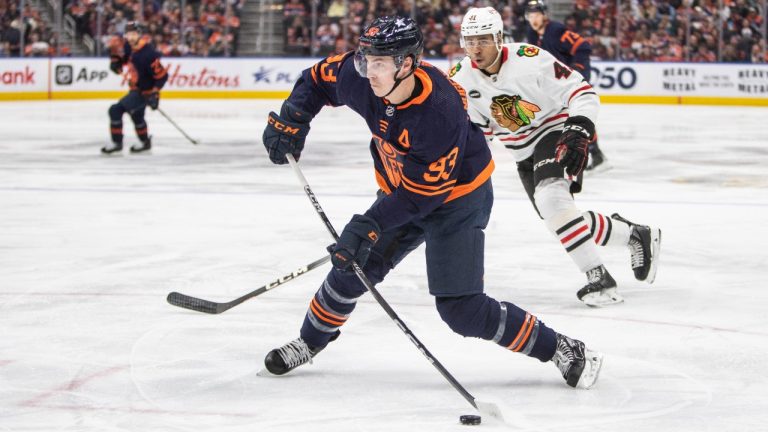 Chicago Blackhawks' Isaak Phillips (41) looks on as Edmonton Oilers' Ryan Nugent-Hopkins (93) shoots on net during second period NHL hockey action in Edmonton, Thursday, Jan. 25, 2024. (Amber Bracken/THE CANADIAN PRESS)