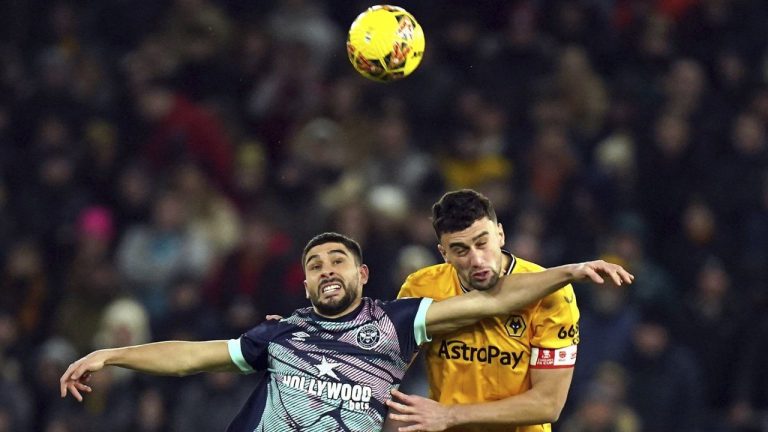 Brentford's Neal Maupay, left, and Wolverhampton Wanderers' Max Kilman battle for the ball during the English FA Cup third round replay soccer match between Wolverhampton Wanderers and Brentford at the Molineux Stadium, Wolverhampton, Tuesday, Jan. 16, 2024. (AP)