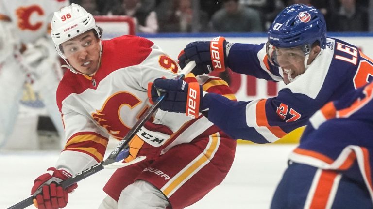 Calgary Flames' Andrei Kuzmenko, left, and New York Islanders' Anders Lee jostle for position, during first period break of an NHL hockey game, Saturday, Feb. 10, 2024, in New York. (Bebeto Matthews/AP) 