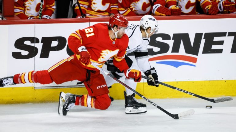 Los Angeles Kings forward Blake Lizotte (46) is checked by Calgary Flames forward Kevin Rooney (21) during third period NHL hockey action in Calgary, Tuesday, Feb. 27, 2024. (Jeff McIntosh/CP)