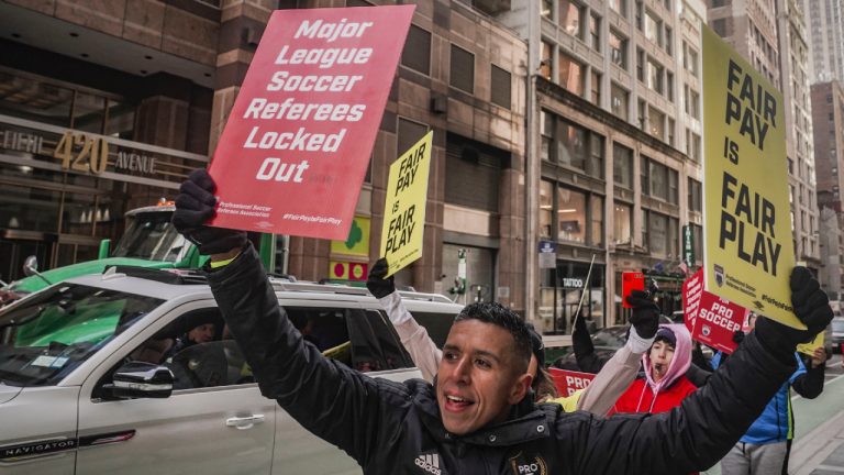 Guido Gonzales, centre, Major League Soccer (MLS) professional referee, picket with other referees and supporters outside MLS headquarters, after MLS implemented a lockout against referees following their rejection of a contract offer, Wednesday, Feb. 21, 2024, in New York. (Bebeto Matthews/AP)