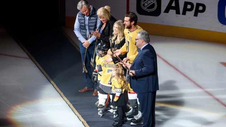 Vegas Golden Knights defenseman Alex Pietrangelo (7) is presented with a golden hockey stick honoring his 1000th NHL game by Golden Knights general manager Kelly McCrimmon, right, during a ceremony prior to an NHL hockey game against the Minnesota Wild, Monday, Feb. 12, 2024, in Las Vegas. (AP Photo/Ian Maule)