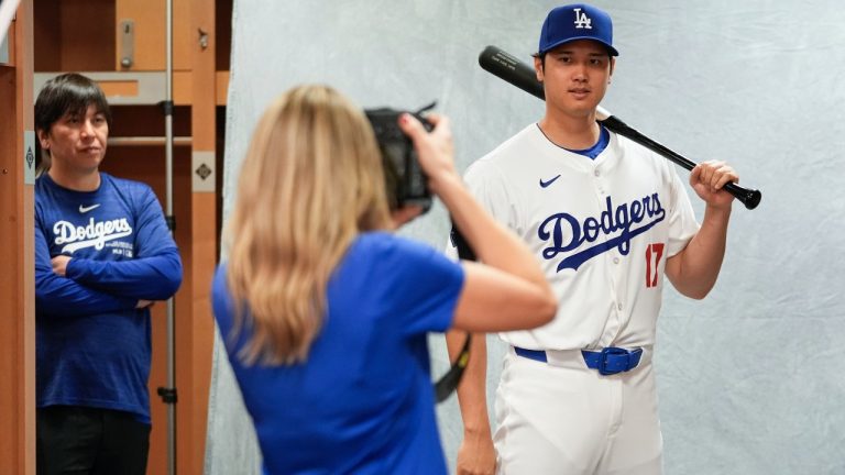 Los Angeles Dodgers Shohei Ohtani poses for a portrait during a spring training baseball team photo day at Camelback Ranch in Phoenix, Wednesday, Feb. 21, 2024. His interpreter, Ippei Mizuhara, is at left. (AP Photo/Ashley Landis)