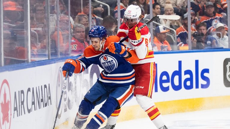 Calgary Flames' Martin Pospisil (76) and Edmonton Oilers' Philip Broberg (86) battle for the puck during third period NHL preseason action in Edmonton on Wednesday October 4, 2023. (Jason Franson/CP)