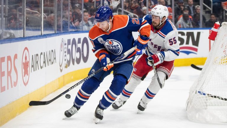 New York Rangers' Ryan Lindgren (55) and Edmonton Oilers' Connor Brown (28) battle for the puck during second period NHL action in Edmonton, Thursday, Oct. 26, 2023. (Jason Franson/CP)