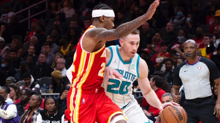 Atlanta Hawks' Cam Reddish (22) defends against Charlotte Hornets' Gordon Hayward (20) during the second half of an NBA basketball game Saturday, Nov. 20, 2021, in Atlanta. (AP Photo/Hakim Wright Sr.)