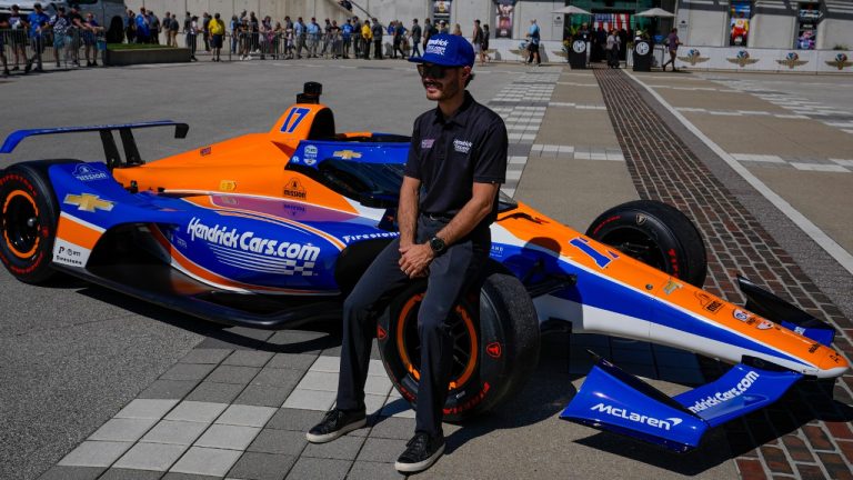 FILE - Kyle Larson sits on the car that he will drive in the IndyCar Indianapolis 500 after is was unveiled at Indianapolis Motor Speedway in Indianapolis, Sunday, Aug. 13, 2023. Larson will attempt to drive both the Indianapolis 500 and the Charlotte NASCAR Cup Series auto races on the same day. (Michael Conroy/AP) 