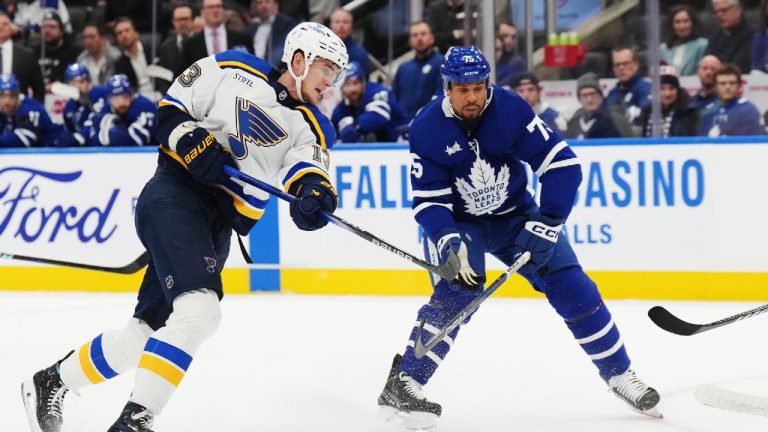 St. Louis Blues forward Alexey Toropchenko (13) shoots as Toronto Maple Leafs forward Ryan Reaves (75) looks on during first period NHL hockey action in Toronto on Tuesday, February 13, 2024. (Nathan Denette/CP)