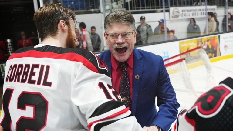 University of New Brunswick Reds head coach Gardiner MacDougall, right, celebrates with Benjamin Corbeil after defeating the University of Alberta Golden Bears to win the gold medal in the USports University Cup men’s hockey championship in Charlottetown, Sunday, March 19, 2023. (Darren Calabrese/CP)