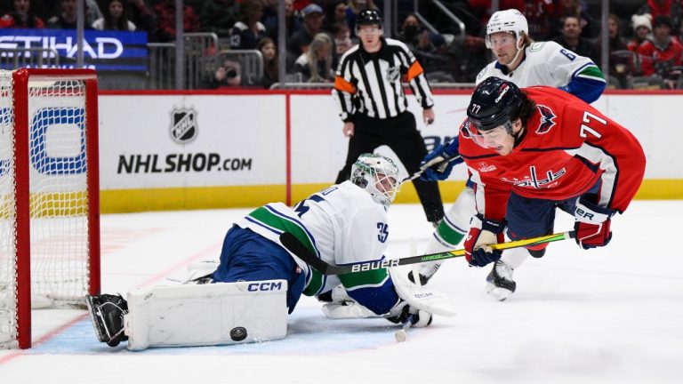 Washington Capitals right wing T.J. Oshie (77) shoots against Vancouver Canucks goaltender Thatcher Demko (35) during the first period of an NHL hockey game, Sunday, Feb. 11, 2024, in Washington. Canucks right wing Brock Boeser, back right, looks on. (Nick Wass/AP)