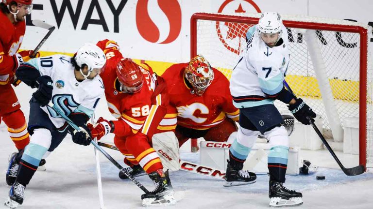 Seattle Kraken forward Matty Beniers (10) and forward Jordan Eberle (7) look for the puck as Calgary Flames goalie Jacob Markstrom (25) kicks it away while defenceman Oliver Kylington (58) defends during first period NHL hockey action in Calgary, Monday, March 4, 2024. (Jeff McIntosh/CP)