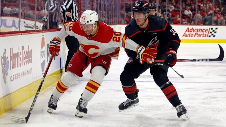 Calgary Flames' Blake Coleman (20) protects the puck from Carolina Hurricanes' Andrei Svechnikov (37) during the first period of an NHL hockey game in Raleigh, N.C., Sunday, March 10, 2024. (AP Photo/Karl B DeBlaker)