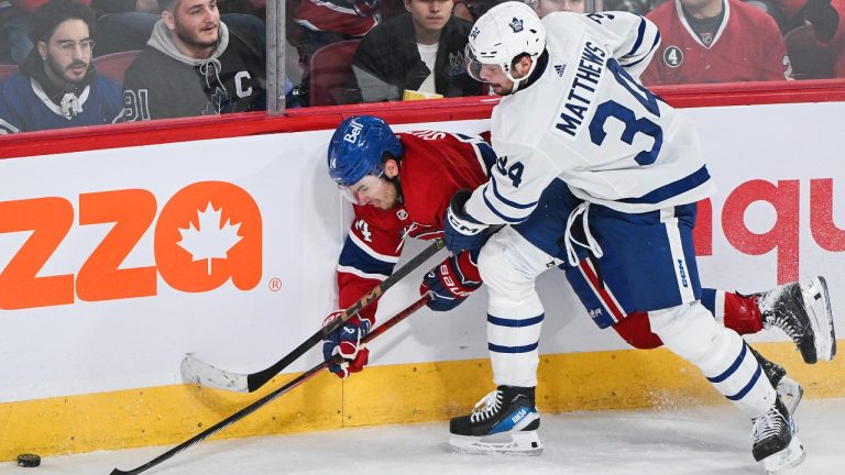 Montreal Canadiens' Nick Suzuki (14) and Toronto Maple Leafs' Auston Matthews compete for the puck along the boards during first period NHL hockey action in Montreal, Saturday, March 9, 2024. (Graham Hughes/CP)