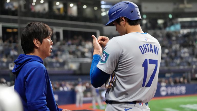 Los Angeles Dodgers designated hitter Shohei Ohtani, right, talks to interpreter Ippei Mizuhara during the fifth inning of an opening day baseball game against the San Diego Padres at the Gocheok Sky Dome in Seoul, South Korea Wednesday, March 20, 2024, in Seoul, South Korea. (Lee Jin-man/AP)