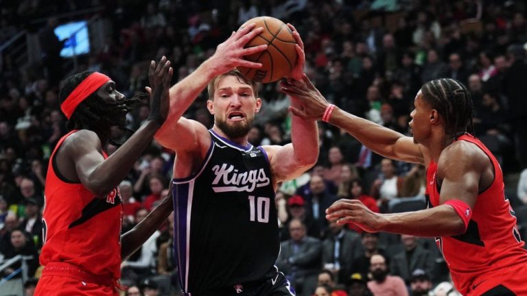 Sacramento Kings forward Domantas Sabonis (10) drives between Toronto Raptors forward Mouhamadou Gueye (left) and guard Jahmi'us Ramsey (right) during second half NBA basketball action in Toronto on Wednesday, March 20, 2024. (CP/Nathan Denette)