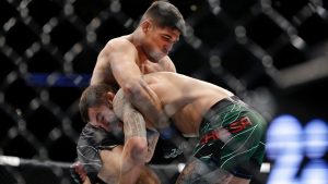 Vicente Luque, top, grapples with Michael Chiesa during their welterweight mixed martial arts bout at UFC 265. (Michael Wyke/AP)