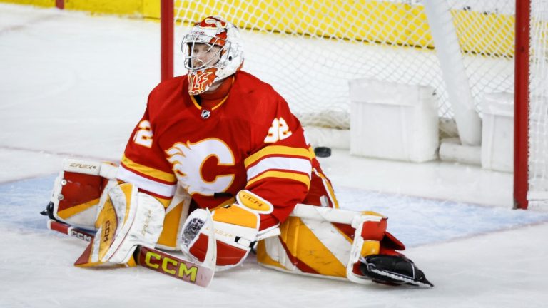 Calgary Flames goalie Dustin Wolf (32) reacts to letting in a goal by Buffalo Sabres forward JJ Peterka (77) during third period NHL hockey action in Calgary, Alta., Sunday, March 24, 2024. (Jeff McIntosh/CP)