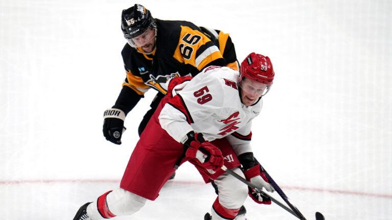 Carolina Hurricanes' Jake Guentzel (59) is defended by Pittsburgh Penguins' Erik Karlsson during the first period of an NHL hockey game in Pittsburgh, Tuesday, March 26, 2024. (Gene J. Puskar/AP)