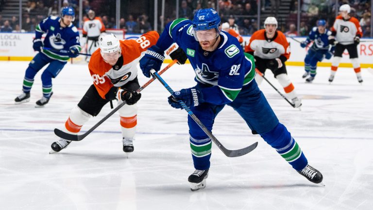 Philadelphia Flyers' Cam Atkinson (89) and Vancouver Canucks' Ian Cole (82) vie for the puck during the second period of an NHL hockey game in Vancouver on Thursday, Dec. 28, 2023. (Ethan Cairns/CP)