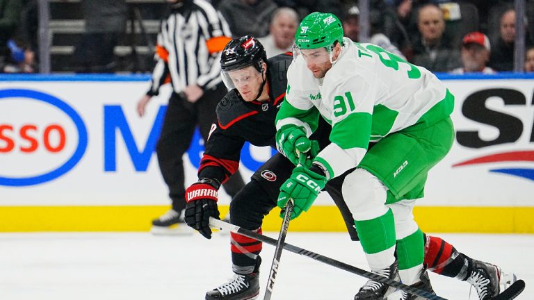 Toronto Maple Leafs centre John Tavares (91) moves the puck under pressure from Carolina Hurricanes left wing Jake Guentzel (59) during first period NHL hockey in Toronto, Saturday, March 16, 2024. (Frank Gunn/CP)