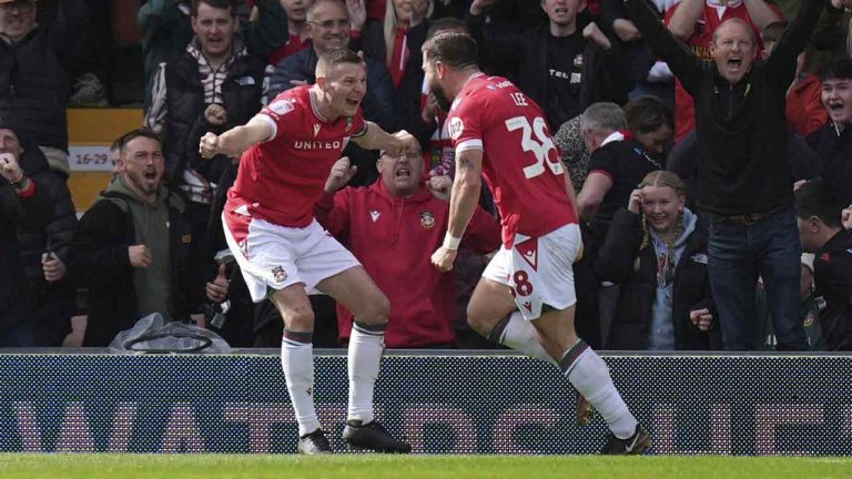 Wrexham's Elliot Lee, right, celebrates with Paul Mullin after scoring their side's first goal of the game during the Sky Bet League Two match at the SToK Cae Ras, Wrexham, England, Saturday April 13, 2024. (Jacob King/PA via AP)