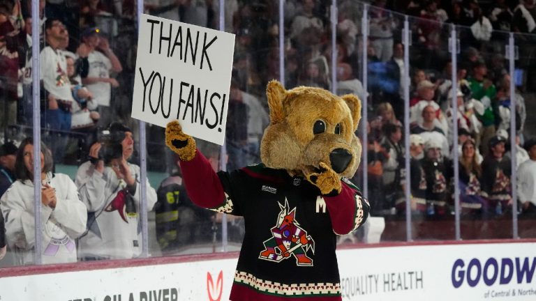 Arizona Coyotes mascot Howler acknowledges holds a sign after the team's NHL hockey game against the Edmonton Oilers on Wednesday, April 17, 2024, in Tempe, Ariz. The Coyotes won 5-2. Team owner Alex Meruelo agreed to sell franchise's hockey operations to Utah Jazz owner Ryan Smith, who intends to move the team to Salt Lake City. (Ross D. Franklin/AP)