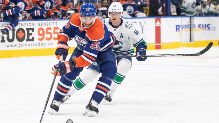 Vancouver Canucks' Elias Pettersson (40) chases Edmonton Oilers' Darnell Nurse (25) during first period NHL action in Edmonton, Saturday, Oct. 14, 2023. (Jason Franson/CP)