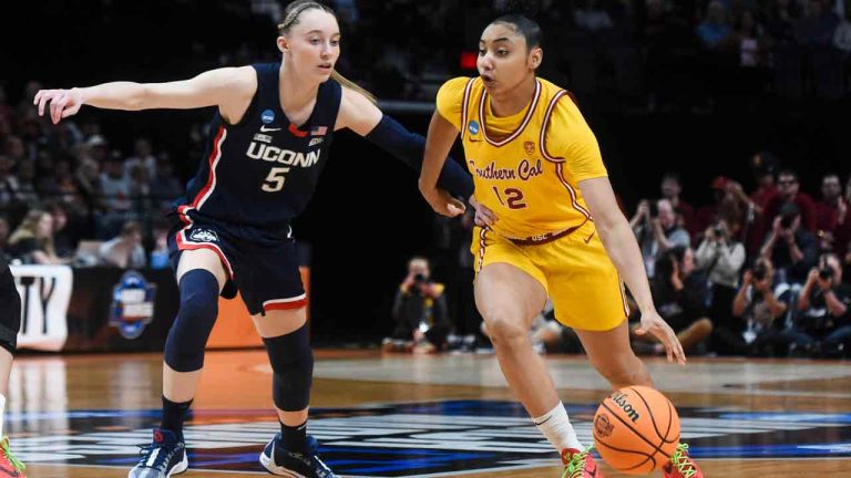 Southern California guard JuJu Watkins (12) drives to the basket past UConn guard Paige Bueckers (5) during the first half of an Elite Eight college basketball game in the women's NCAA Tournament, Monday, April 1, 2024, in Portland, Ore. (Steve Dykes/AP)